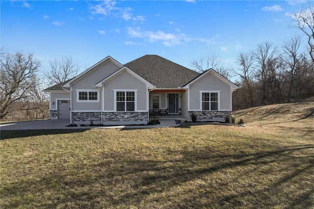 view of front facade featuring a front yard, an attached garage, and stone siding