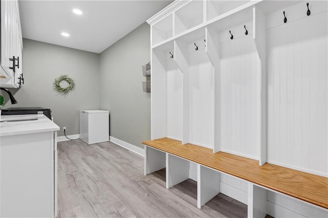 mudroom featuring a sink, light wood-type flooring, baseboards, and recessed lighting