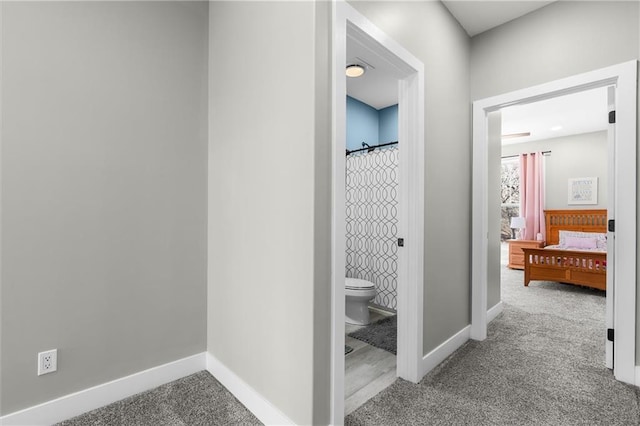 bathroom with a shower with curtain, toilet, and baseboards