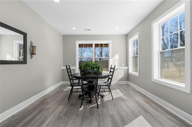 dining room featuring visible vents, wood finished floors, and baseboards