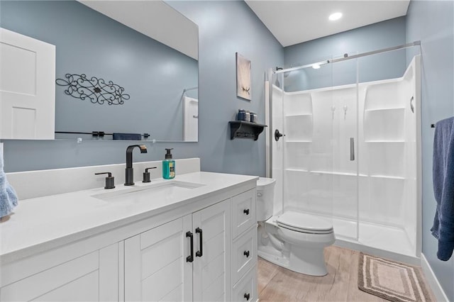 full bath featuring wood finished floors, toilet, a stall shower, and vanity