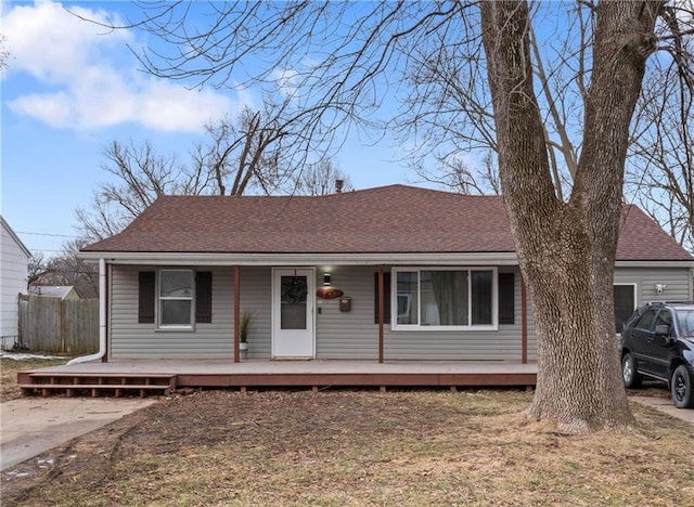 view of front of property featuring covered porch, driveway, roof with shingles, and a garage