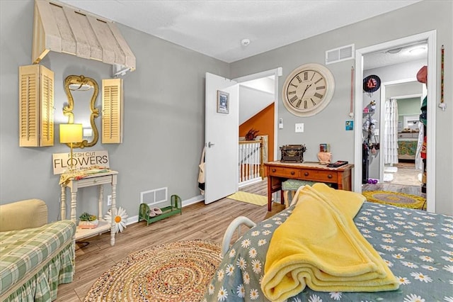 sitting room featuring visible vents, baseboards, and wood finished floors