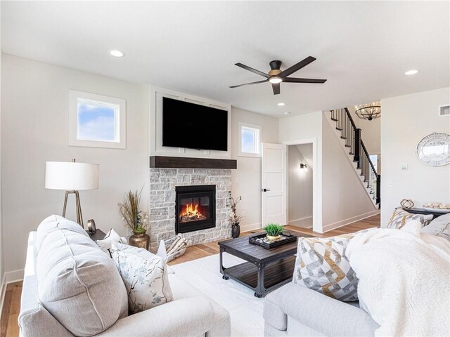 living room with light wood-style floors, a fireplace, stairway, and recessed lighting