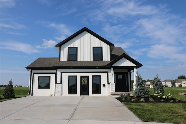 15619 Sheridan Ct, Basehor, KS 66007 - view of front of house with board and batten siding, a front lawn, a shingled roof, and stone siding