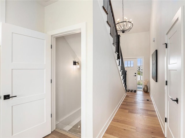 15619 Sheridan Ct, Basehor, KS 66007 - corridor with a chandelier, baseboards, stairs, light wood-style floors, and a high ceiling