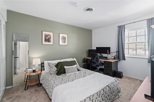 bedroom with baseboards, a closet, visible vents, and light colored carpet