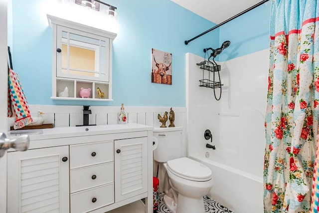 full bath with a wainscoted wall, vanity, toilet, and shower / tub combo with curtain