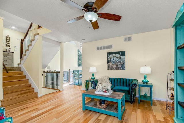 sitting room featuring visible vents, a textured ceiling, and wood finished floors