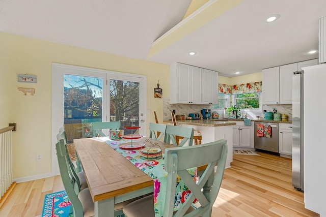 dining space featuring light wood-style flooring, baseboards, and recessed lighting