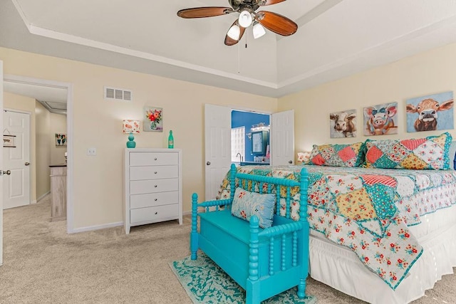 carpeted bedroom featuring baseboards, visible vents, a ceiling fan, a tray ceiling, and vaulted ceiling