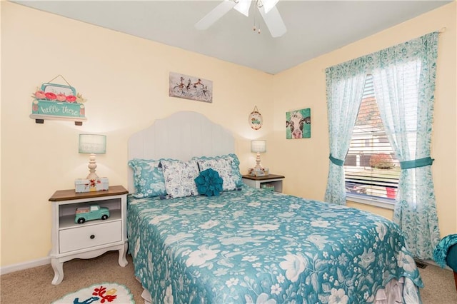 carpeted bedroom with ceiling fan and baseboards