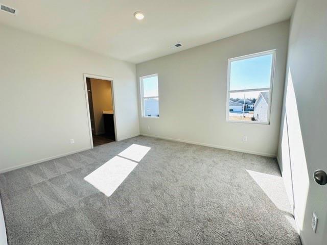 unfurnished bedroom with light colored carpet, visible vents, and baseboards