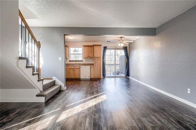 unfurnished living room featuring dark wood-style floors, stairs, baseboards, and a textured ceiling