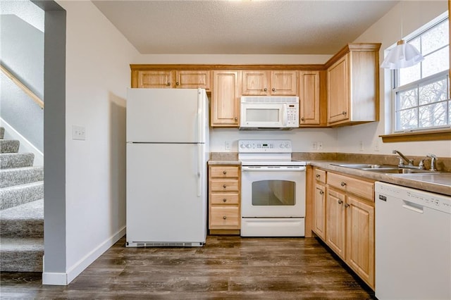 kitchen with light brown cabinetry, dark wood-type flooring, a sink, white appliances, and baseboards