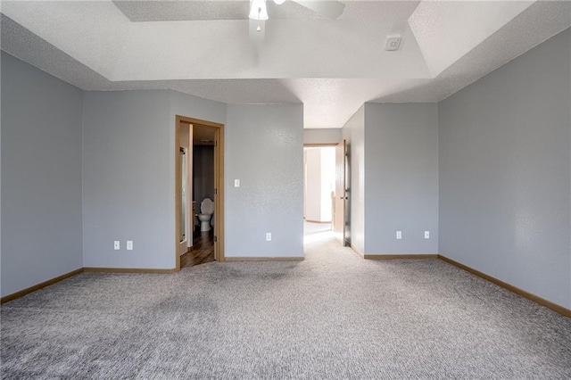 carpeted empty room with ceiling fan, baseboards, and a textured ceiling