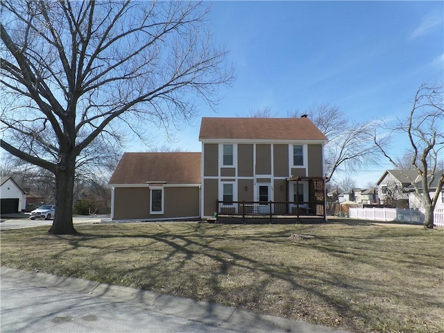 view of front of property with a wooden deck, a front yard, and fence