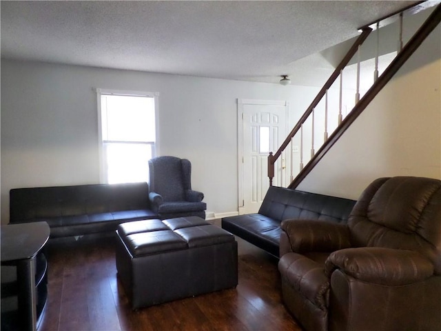 living area featuring stairway, wood finished floors, and a textured ceiling