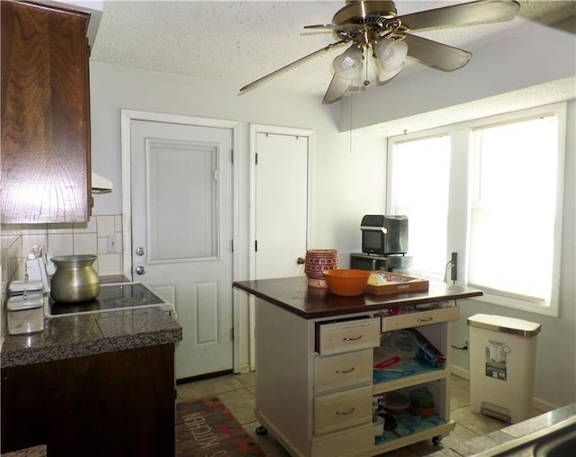 kitchen with cooktop, tile countertops, decorative backsplash, light tile patterned flooring, and a textured ceiling