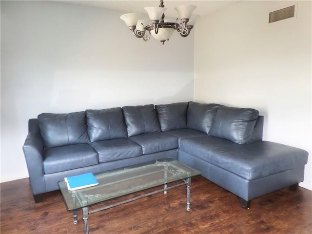 living area featuring a notable chandelier, visible vents, and wood finished floors