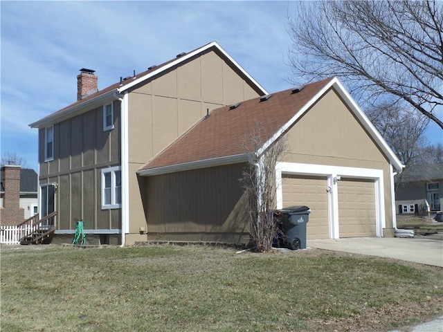 view of side of property with a lawn, roof with shingles, a chimney, and entry steps