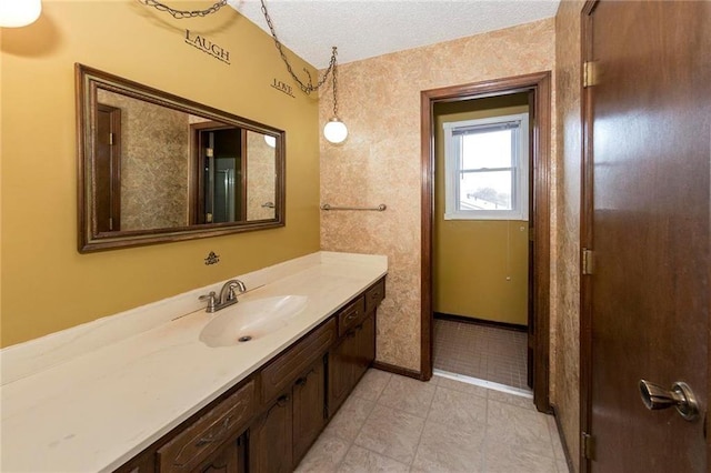 bathroom featuring vanity, baseboards, and a textured ceiling