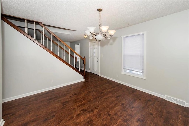 interior space with stairway, wood finished floors, visible vents, baseboards, and a textured ceiling