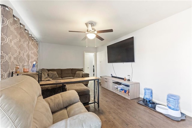 living room featuring baseboards, wood finished floors, and a ceiling fan