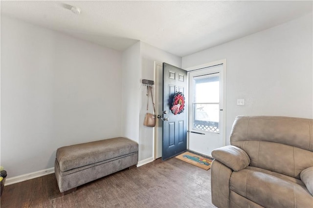 living area featuring baseboards and wood finished floors