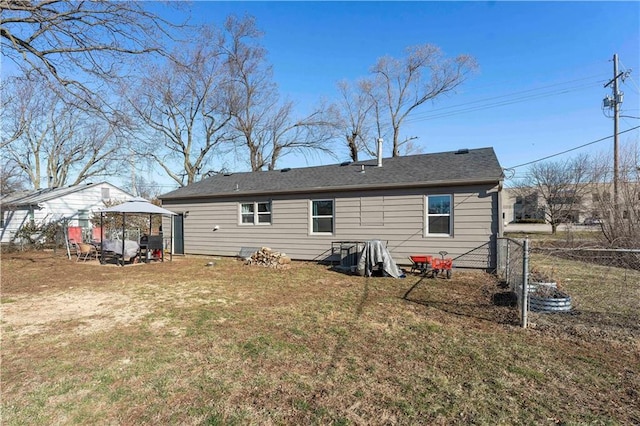 back of house featuring a gazebo, a yard, and fence