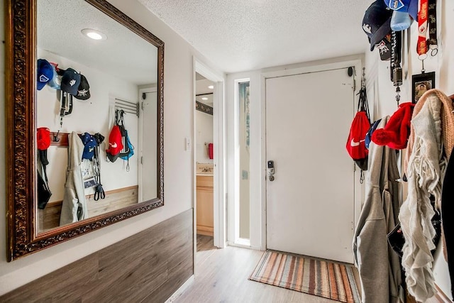 entryway with a textured ceiling and wood finished floors