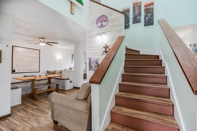 stairway featuring ceiling fan and wood finished floors