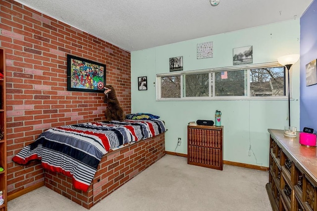 carpeted bedroom with brick wall, baseboards, and a textured ceiling