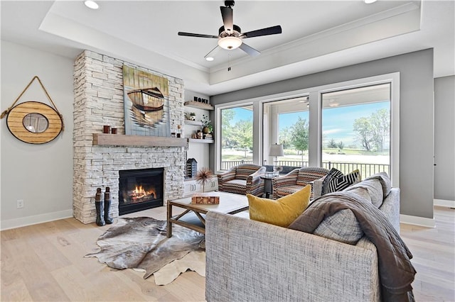 15026 W 129th Ter, Olathe, KS 66062 - living room featuring a tray ceiling, ceiling fan, light wood-style flooring, a stone fireplace, and recessed lighting