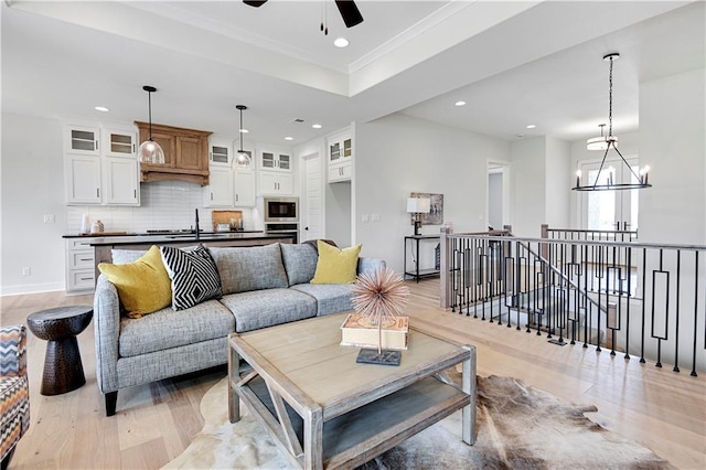 15026 W 129th Ter, Olathe, KS 66062 - living area featuring light wood-style flooring, recessed lighting, ceiling fan, a chandelier, and crown molding