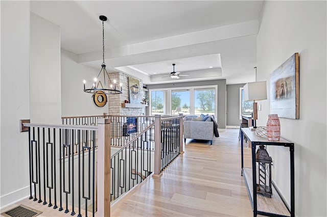 15026 W 129th Ter, Olathe, KS 66062 - hallway with a raised ceiling, light wood-style floors, an upstairs landing, a chandelier, and recessed lighting