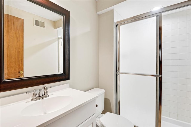 bathroom featuring vanity, toilet, visible vents, and a stall shower