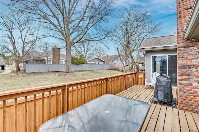 wooden terrace featuring area for grilling, a yard, and fence