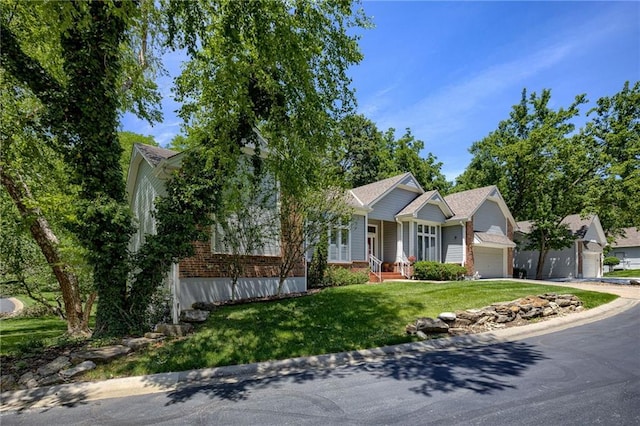 view of front facade featuring a front yard, brick siding, driveway, and an attached garage