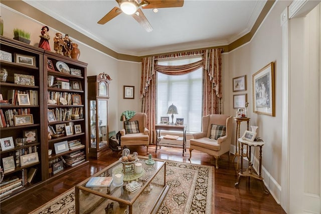 sitting room featuring ceiling fan, ornamental molding, dark wood finished floors, and baseboards