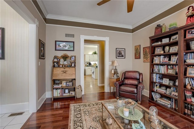 sitting room featuring visible vents, crown molding, baseboards, and wood finished floors