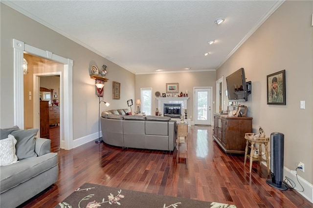 living area with dark wood-style floors, baseboards, ornamental molding, and a tile fireplace