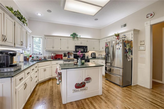 kitchen with dark countertops, white cabinets, and black appliances