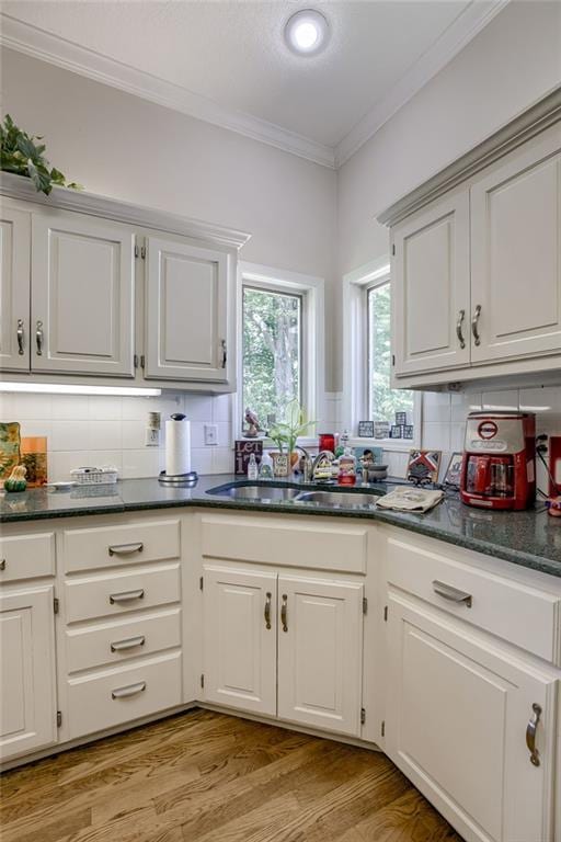 kitchen with a sink, light wood-style flooring, and white cabinets