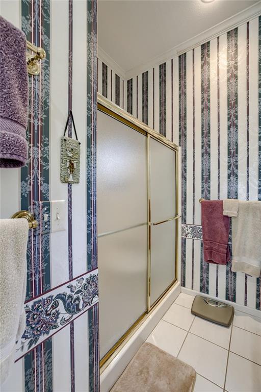 bathroom with ornamental molding and tile patterned flooring