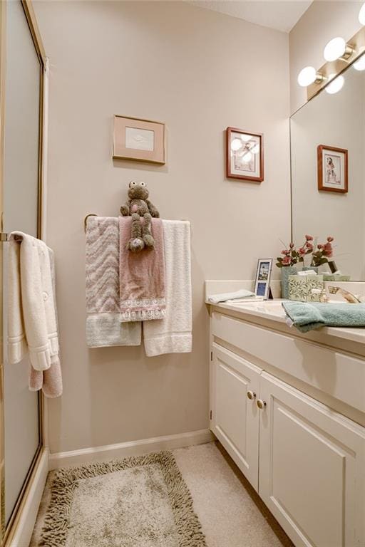 full bath featuring vanity, baseboards, and an enclosed shower