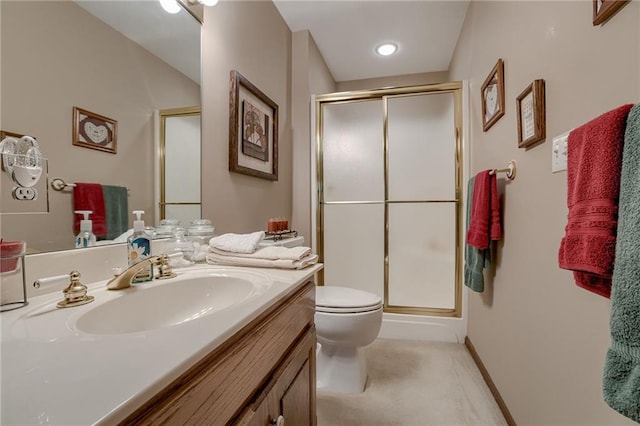 full bath featuring toilet, a stall shower, vanity, and baseboards