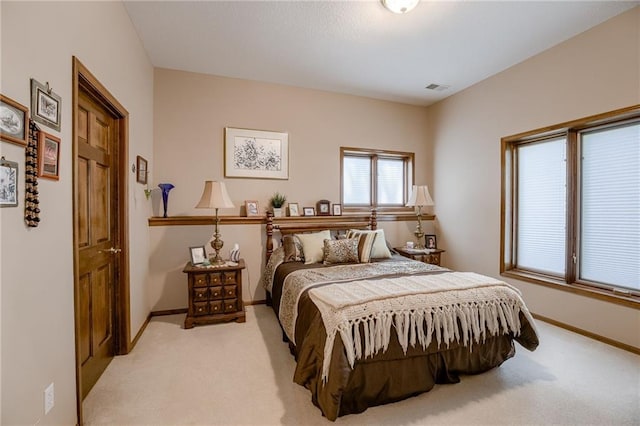 bedroom featuring light carpet, visible vents, and baseboards