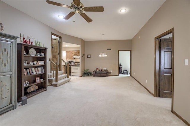 sitting room featuring ceiling fan with notable chandelier, baseboards, and light colored carpet