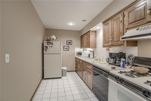 kitchen with light tile patterned floors, light countertops, white appliances, under cabinet range hood, and baseboards